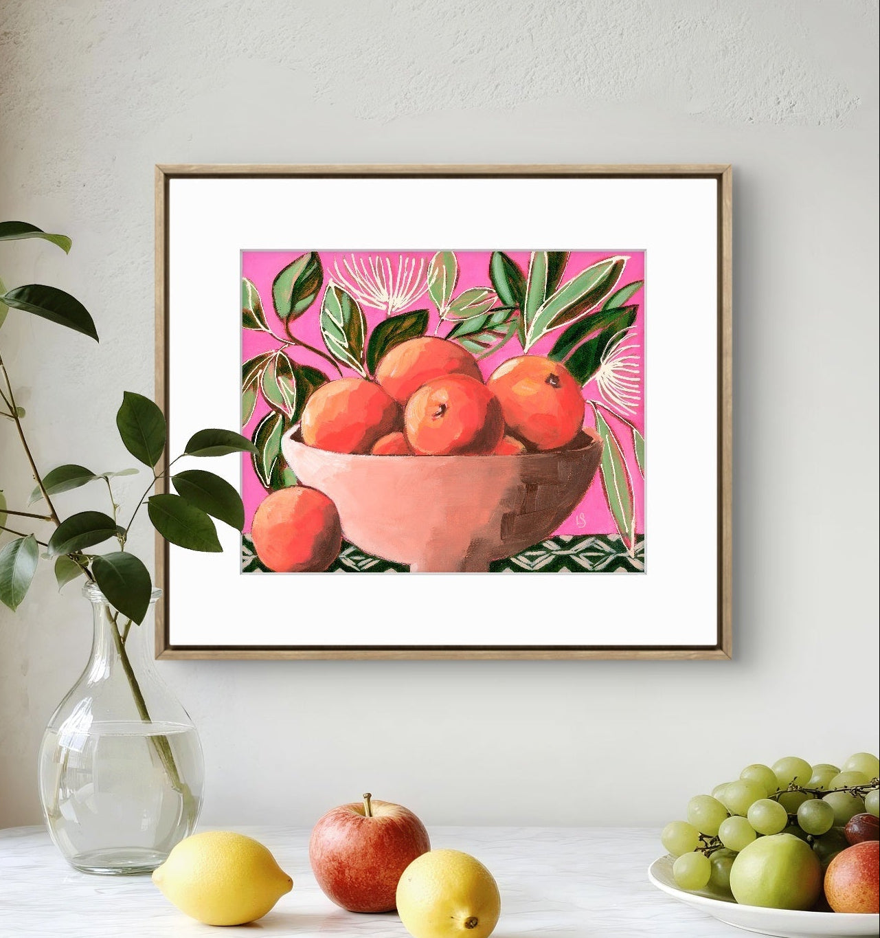 Framed artwork of a bowl of fruit on a table with real fruits